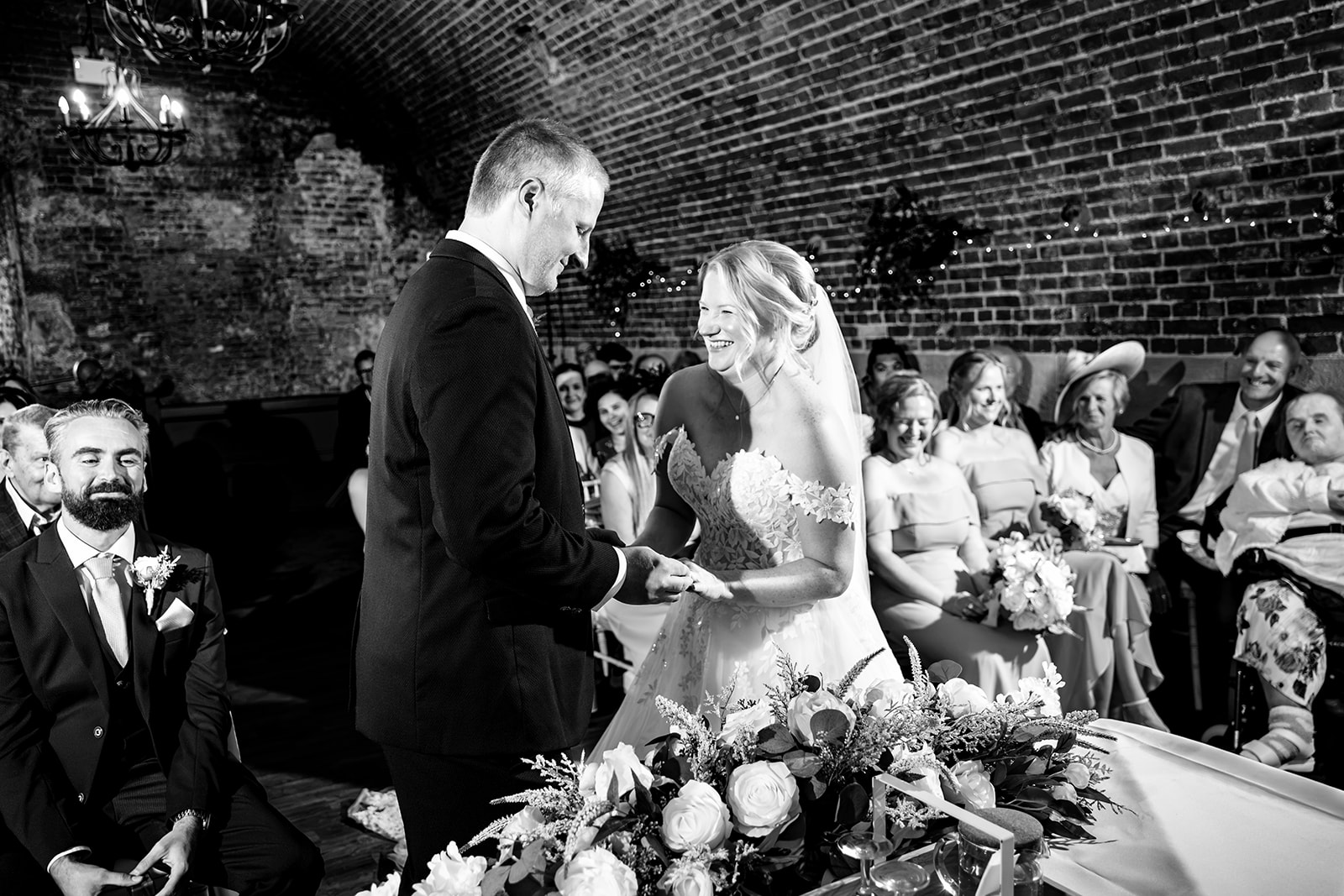 Bride and groom during their ceremony in the brick vaulted room at The Square Tower, black and white