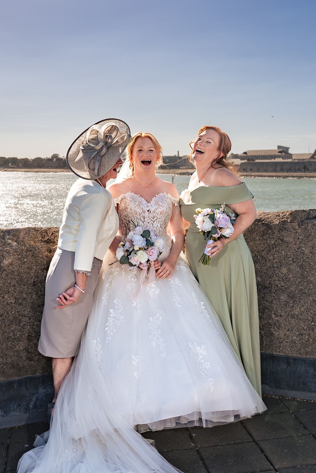 Bride laughing with her bridesmaid and a guest on the rooftop of The Square Tower