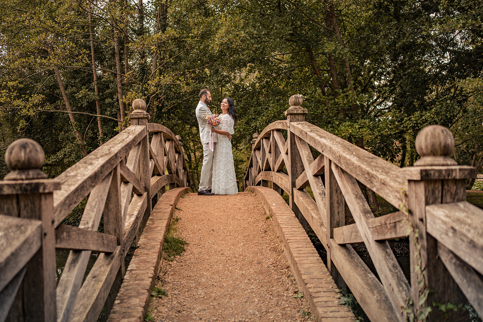 Couple on the wooden bridge path at Staunton Country Park post wedding shoot