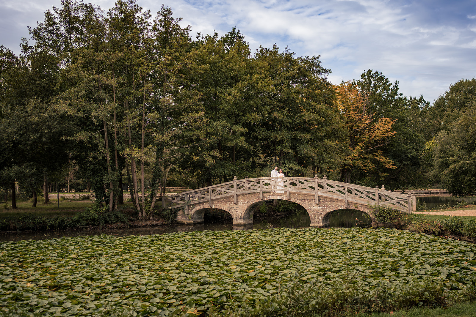 Couple on the bridge over the lily pond at Staunton Country Park, Havant, rim lit with off camera flash