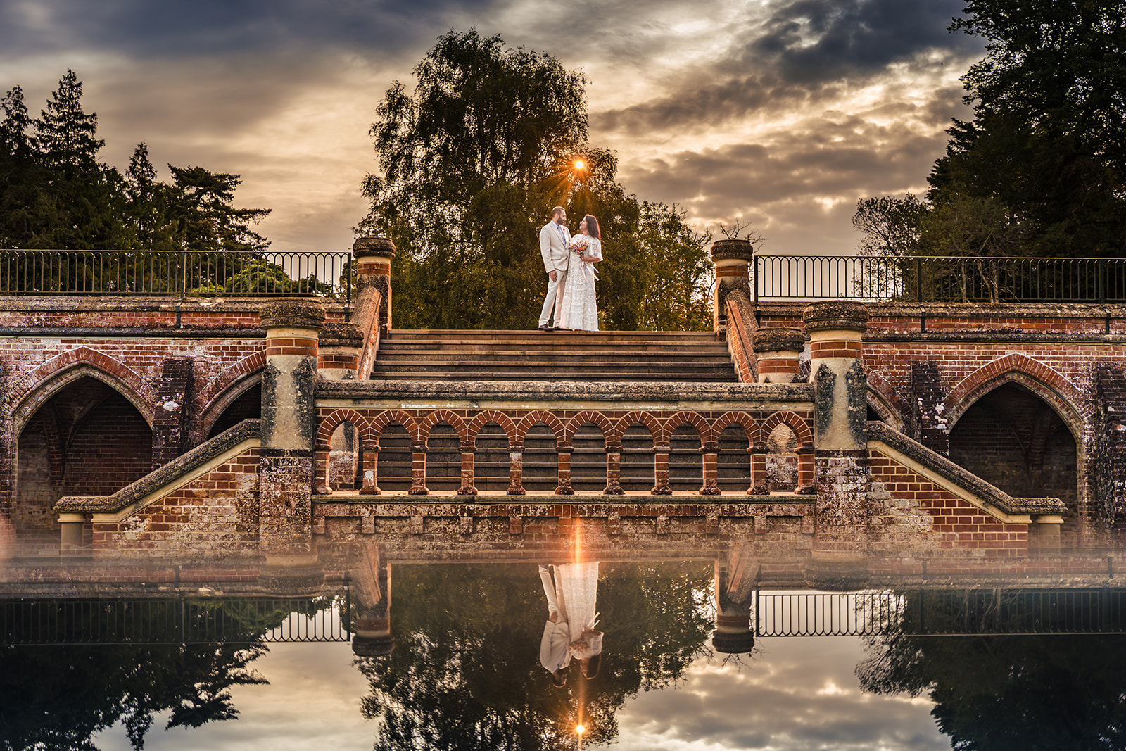 In camera mirror reflection of the couple on the stone terrace at Staunton Country Park, with an orange gelled flash creating the sun