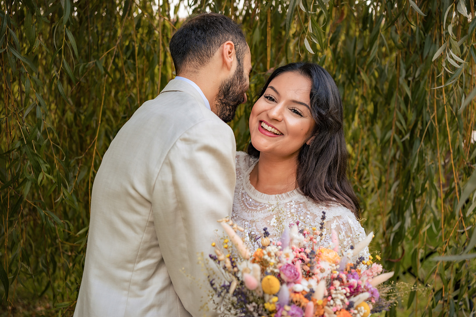 Bride laughing as her husband holds her close during their post wedding shoot at Staunton Country Park