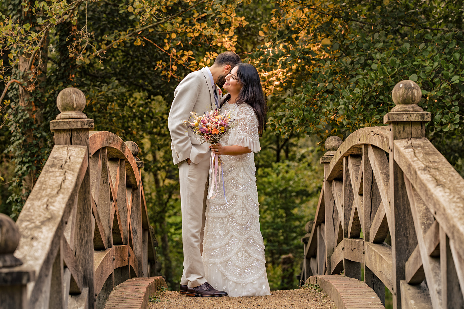 Couple sharing a kiss between the bridge railings at Staunton Country Park