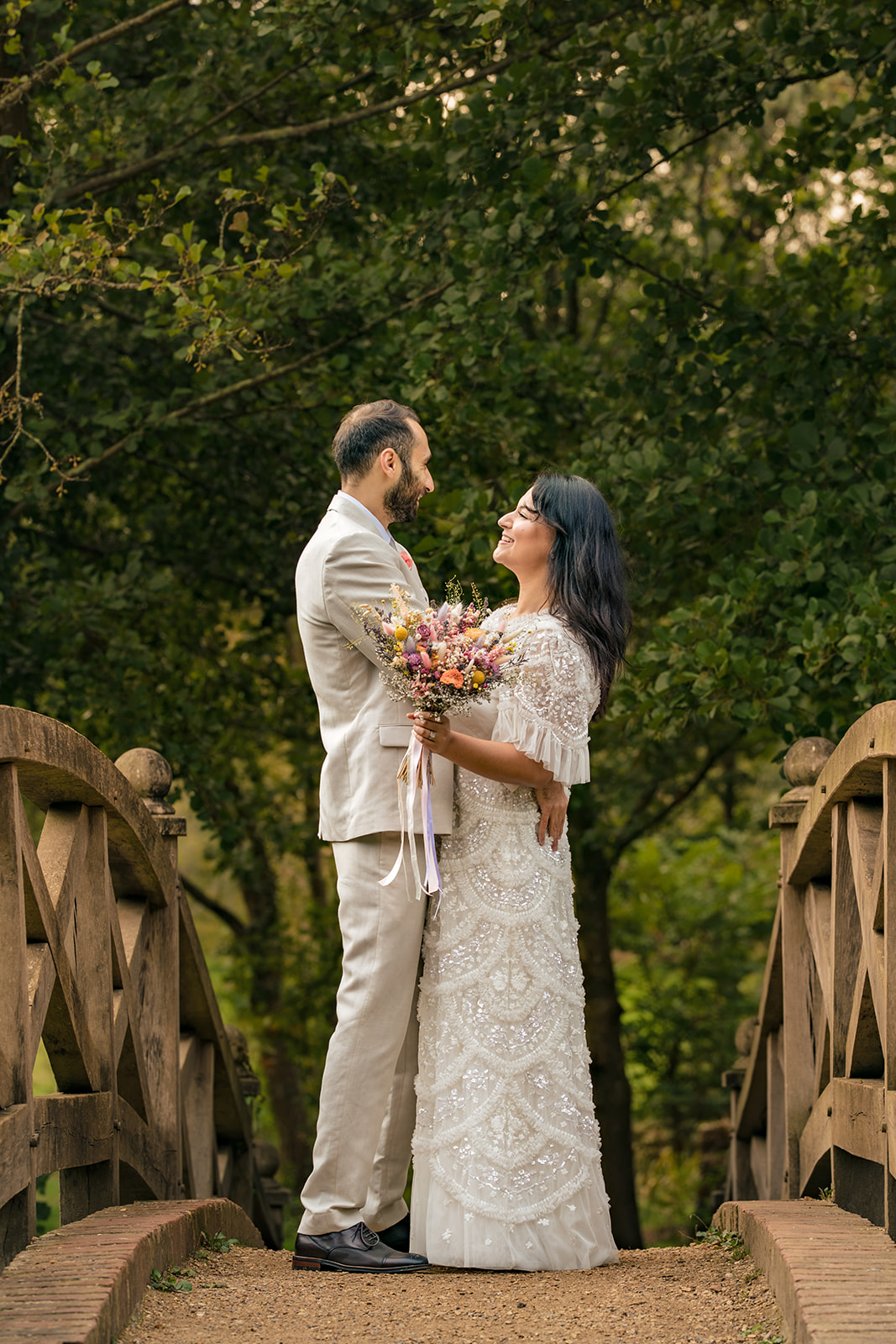 Couple smiling at each other by the bridge at Staunton Country Park