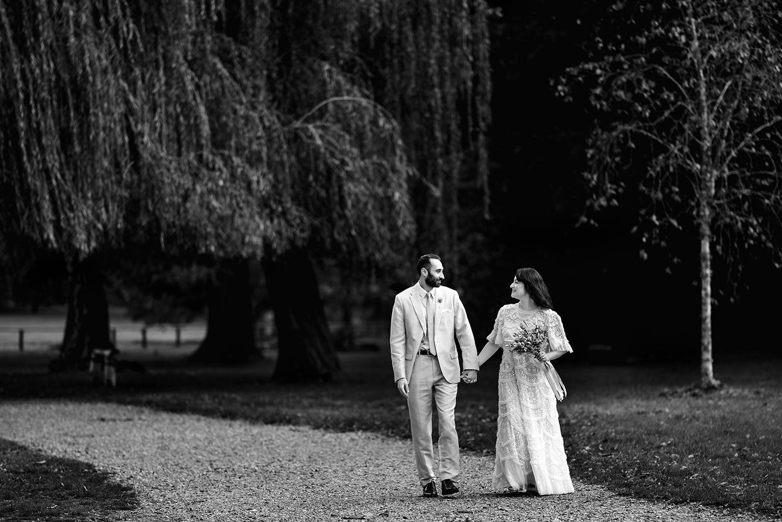 Couple walking hand in hand through Staunton Country Park, black and white