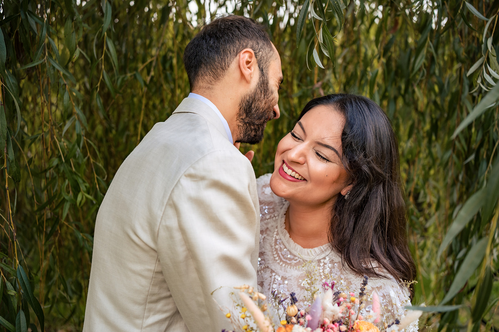 Couple laughing together under the willow trees at Staunton Country Park