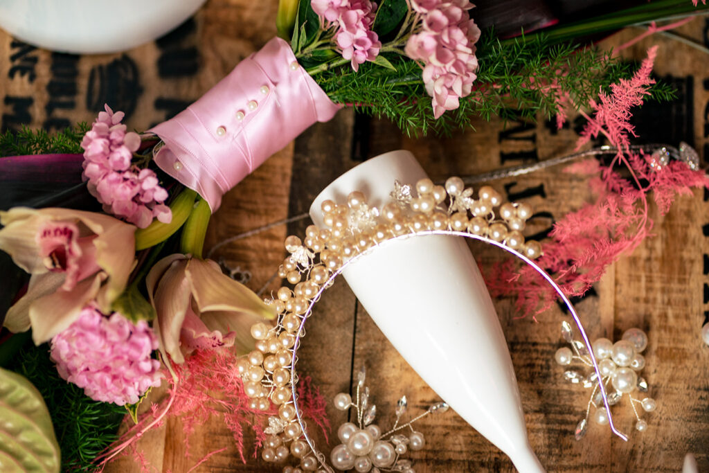 Wedding shoes among pink flowers at Ashbys and Southsea Castle, styled shoot