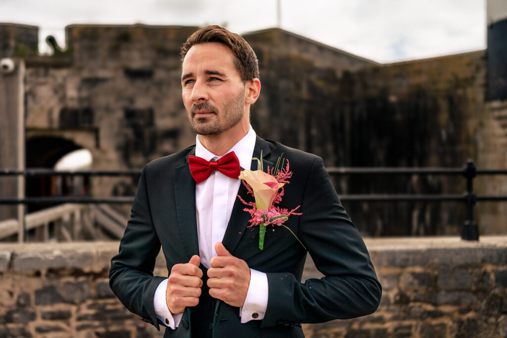 Groom in a tuxedo and red bow tie at Ashbys and Southsea Castle, styled shoot