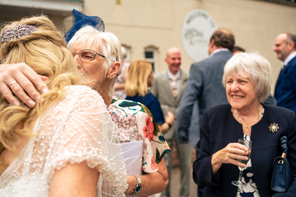 Bride hugging a guest after the ceremony at Lodge Hill Centre, West Sussex