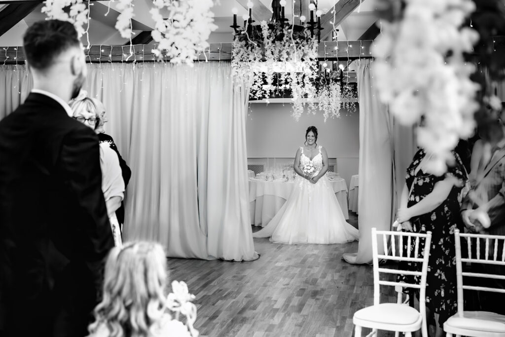 Bride walking down the aisle, black and white at Newtown House Hotel, Hayling Island