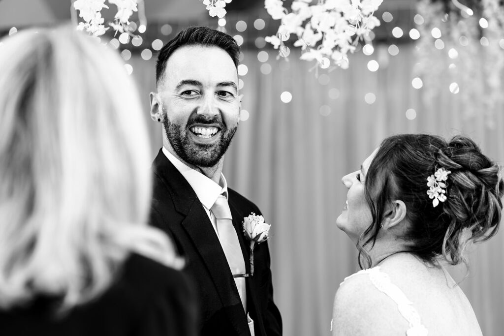 Groom beaming during the ceremony, black and white at Newtown House Hotel, Hayling Island
