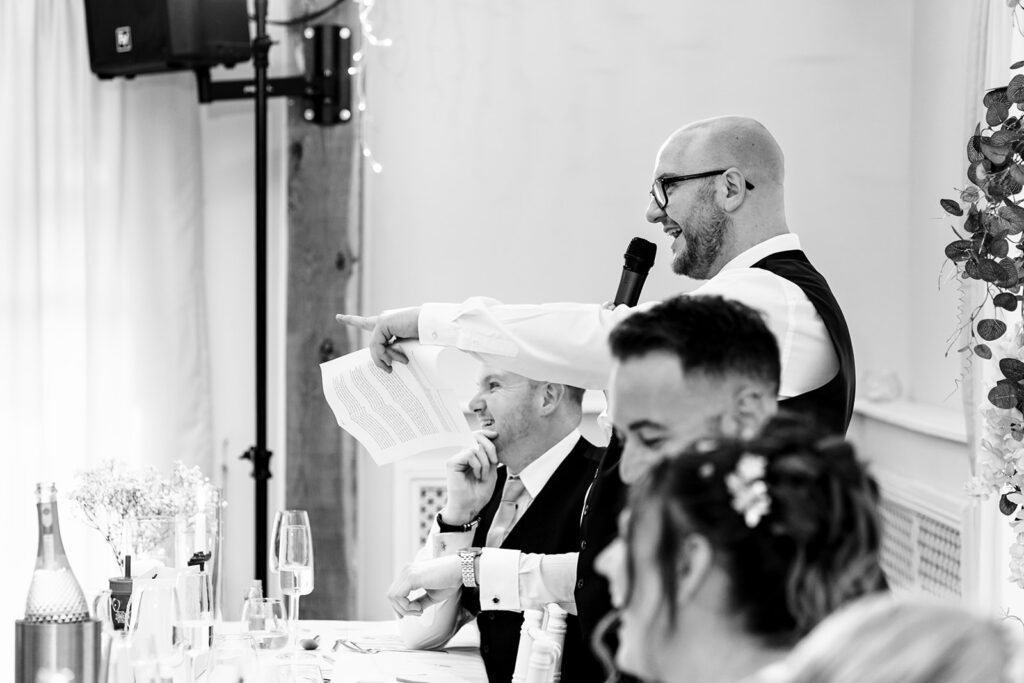 Bride laughing during the speeches, black and white at Newtown House Hotel, Hayling Island