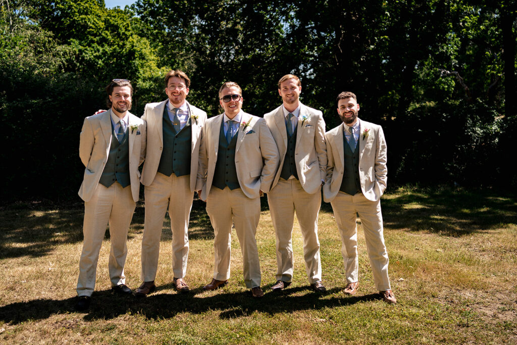 Groom and groomsmen lined up in the field at Tournerbury Woods Estate, Hayling Island