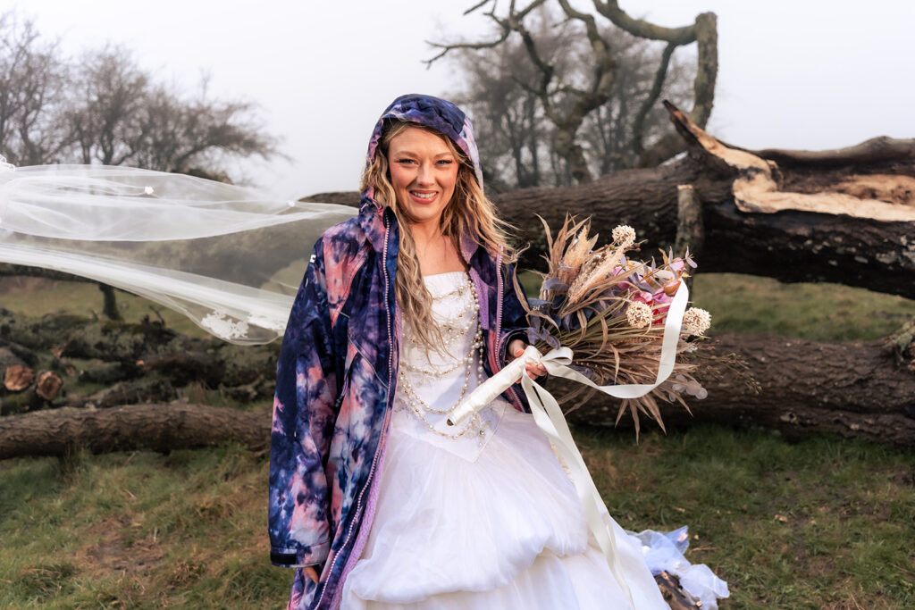 Bride in a blanket with a bouquet at Butser Hill, Wuthering Heights styled shoot