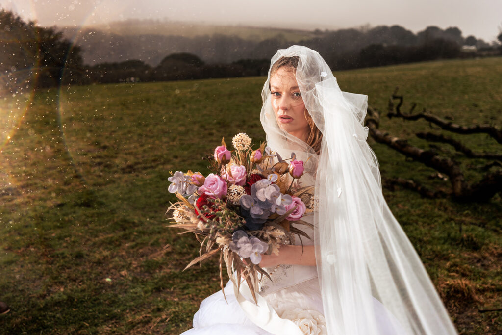 Bride in the misty field with bouquet at Butser Hill, Wuthering Heights styled shoot