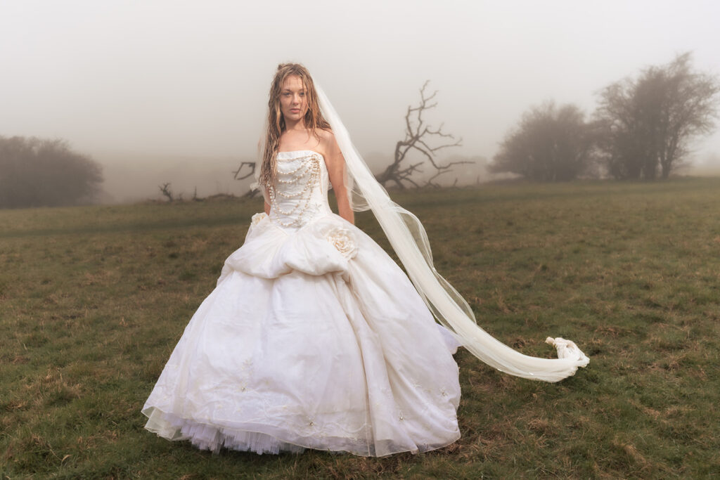 Bride on the misty hill with a long veil at Butser Hill, Wuthering Heights styled shoot